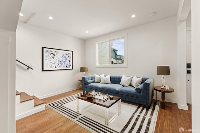 living area with stairs, baseboards, wood finished floors, and recessed lighting