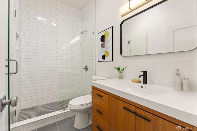 bathroom featuring a stall shower, vanity, toilet, and tile patterned floors