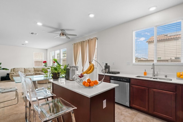 kitchen with light countertops, stainless steel dishwasher, a kitchen island, and a sink
