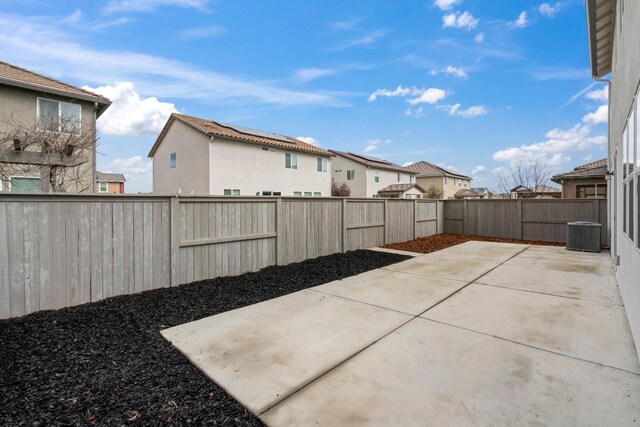 view of patio with central AC, a fenced backyard, and a residential view