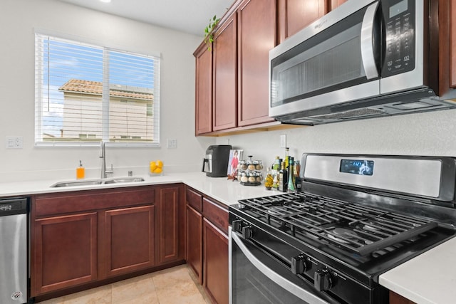 kitchen with appliances with stainless steel finishes, light countertops, and a sink