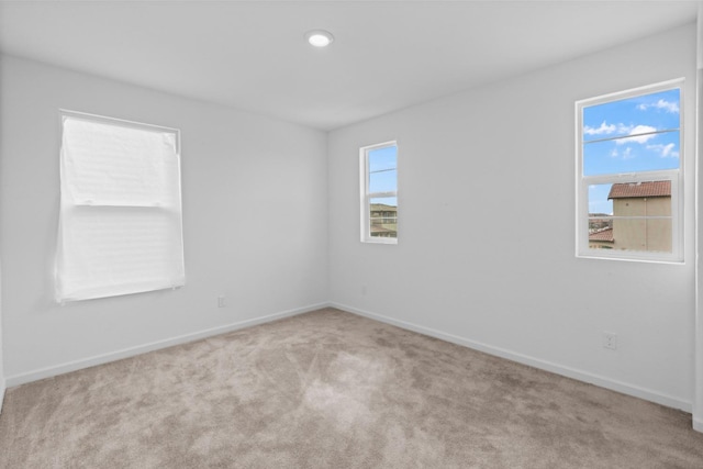 carpeted spare room featuring baseboards