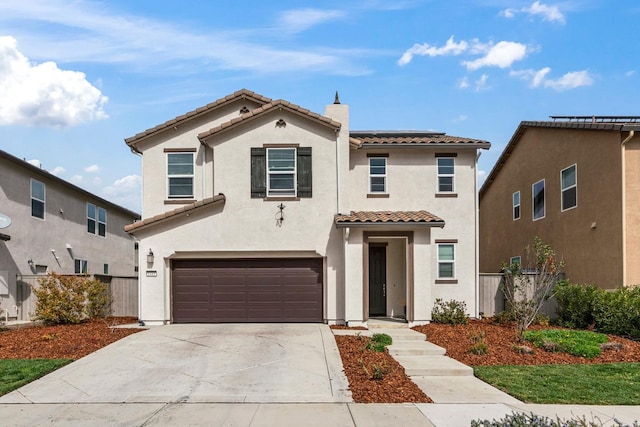 mediterranean / spanish-style home featuring a garage, driveway, a tiled roof, and stucco siding