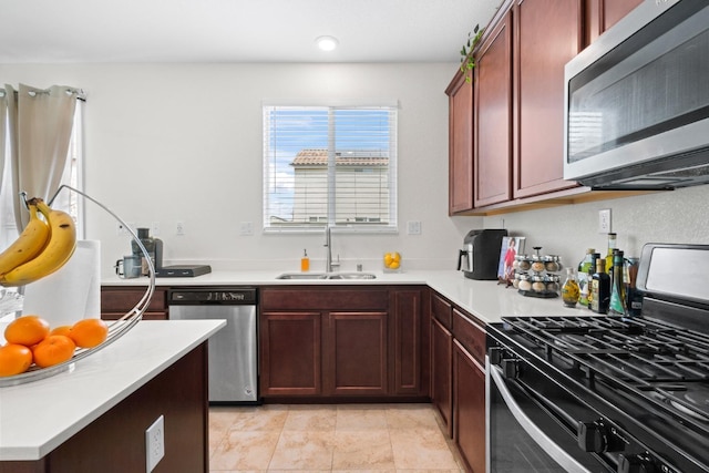 kitchen with stainless steel appliances, light countertops, a sink, and light tile patterned floors