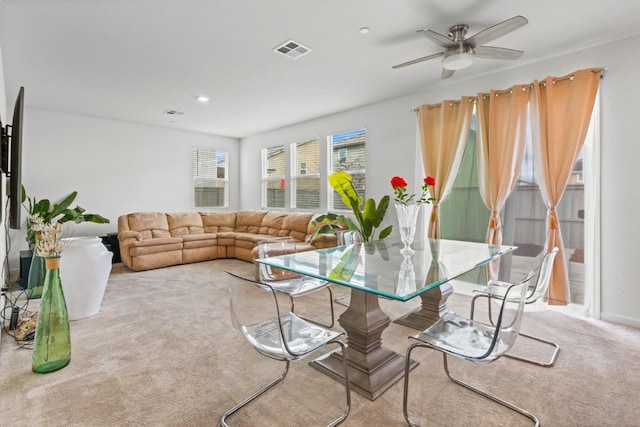 living area with carpet floors, visible vents, and a ceiling fan