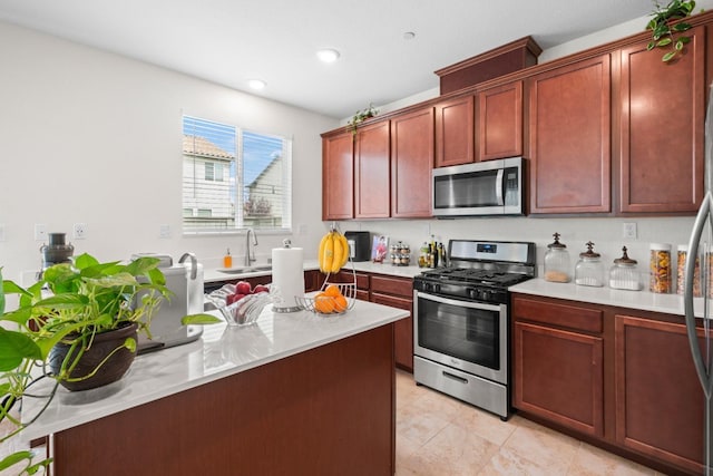kitchen featuring appliances with stainless steel finishes, light countertops, dark brown cabinets, a sink, and recessed lighting