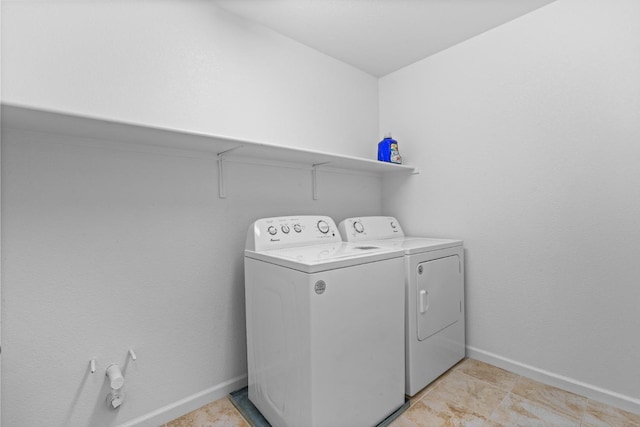 laundry room featuring laundry area, baseboards, and washing machine and clothes dryer