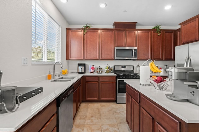 kitchen with light countertops, appliances with stainless steel finishes, a sink, and recessed lighting