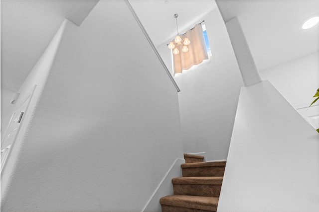 staircase featuring an inviting chandelier