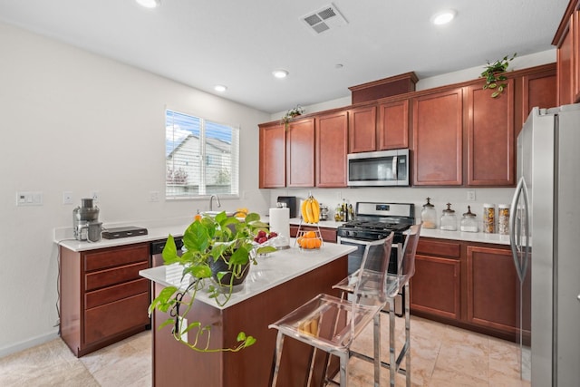 kitchen with a center island, recessed lighting, light countertops, visible vents, and appliances with stainless steel finishes