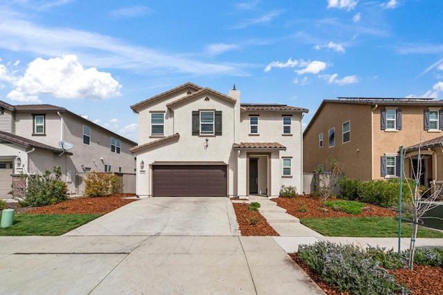 mediterranean / spanish-style home with a tile roof, a chimney, stucco siding, concrete driveway, and an attached garage