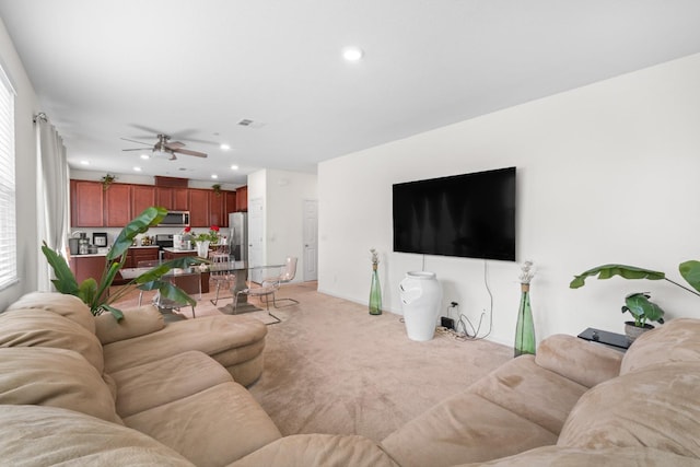 living room featuring ceiling fan, recessed lighting, baseboards, and light colored carpet