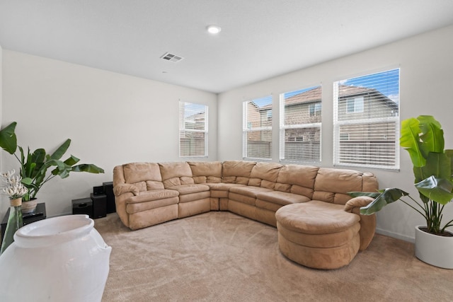 living area with plenty of natural light, visible vents, and light colored carpet