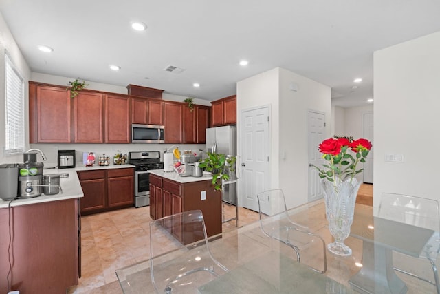 kitchen featuring stainless steel appliances, a kitchen island, light countertops, and recessed lighting