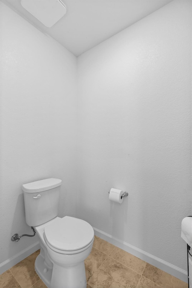 bathroom featuring toilet and baseboards