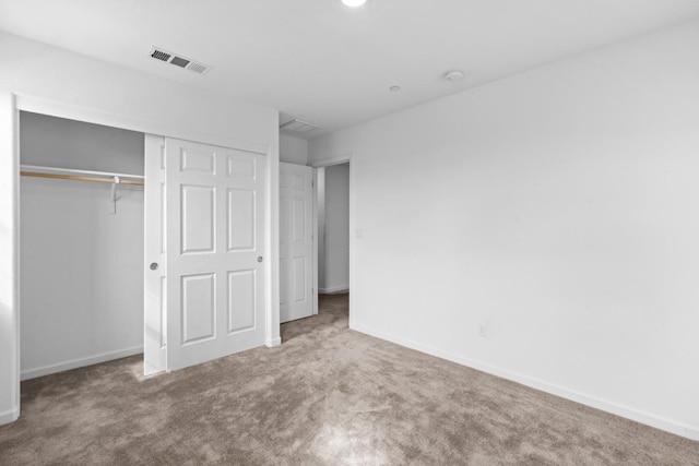 unfurnished bedroom featuring carpet, a closet, visible vents, and baseboards