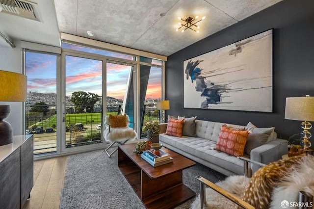 living room featuring a wall of windows, wood finished floors, and visible vents