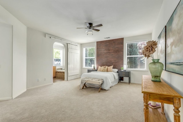 549 Fresian Dr, Oakdale, CA 95361 - bedroom featuring light colored carpet, baseboards, ensuite bath, arched walkways, and ceiling fan