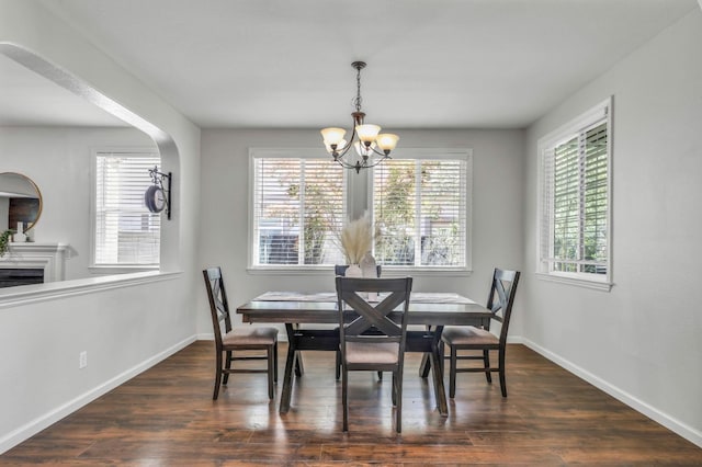 549 Fresian Dr, Oakdale, CA 95361 - dining area featuring a chandelier, plenty of natural light, dark wood-style flooring, and baseboards