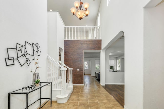 549 Fresian Dr, Oakdale, CA 95361 - entryway with stairway, a chandelier, arched walkways, a high ceiling, and baseboards