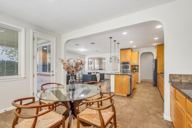 549 Fresian Dr, Oakdale, CA 95361 - dining space featuring arched walkways, recessed lighting, light tile patterned floors, and plenty of natural light