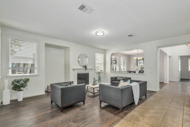 549 Fresian Dr, Oakdale, CA 95361 - living area with a glass covered fireplace, a chandelier, baseboards, and arched walkways