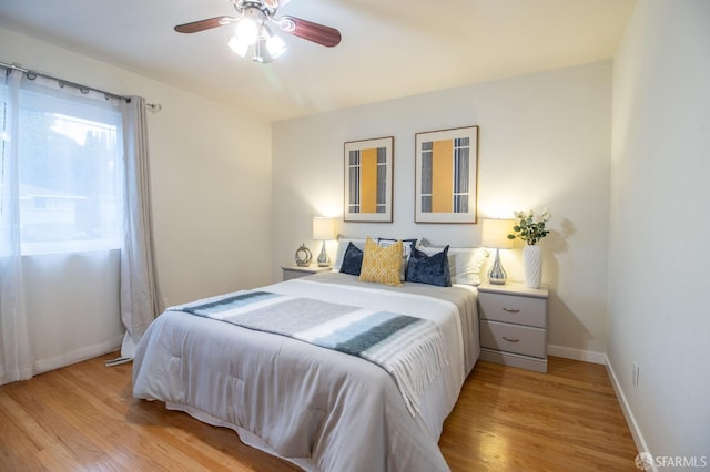 bedroom with baseboards, a ceiling fan, and light wood finished floors