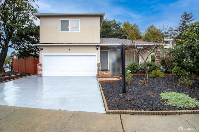 traditional-style home with brick siding, stucco siding, driveway, and fence