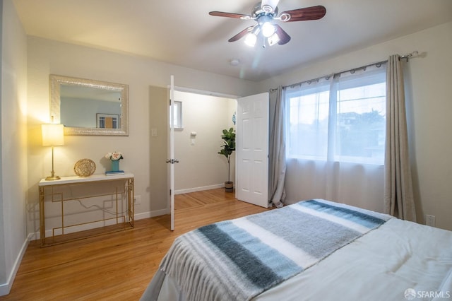 bedroom featuring baseboards, light wood-style floors, and ceiling fan