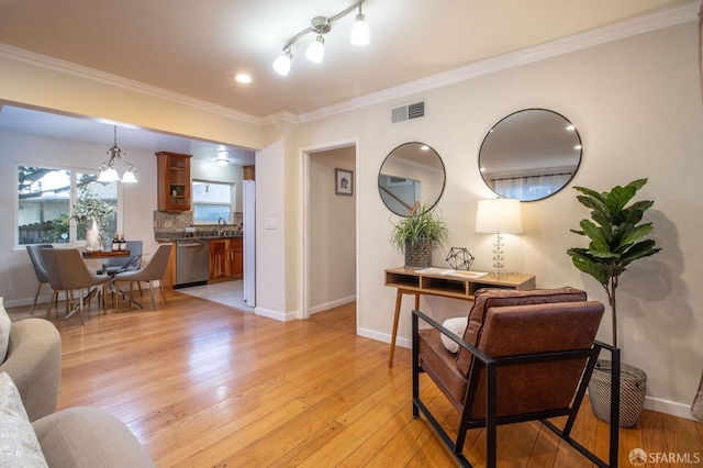 living room with baseboards, light wood-style flooring, and crown molding