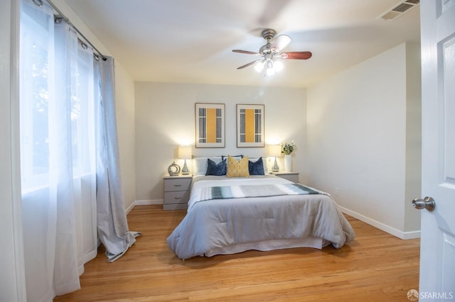 bedroom featuring visible vents, ceiling fan, baseboards, and light wood-style floors