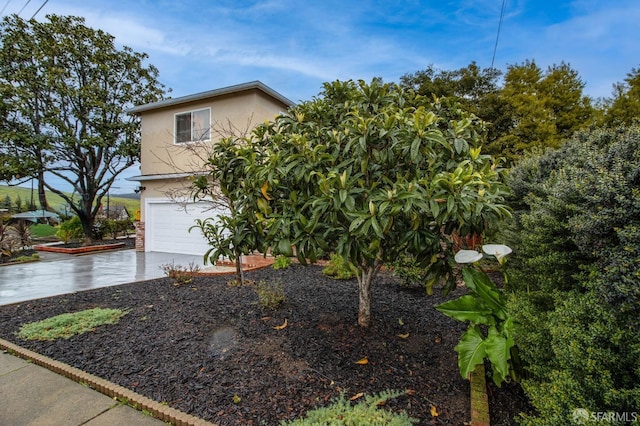 view of front of home featuring concrete driveway, a garage, and stucco siding