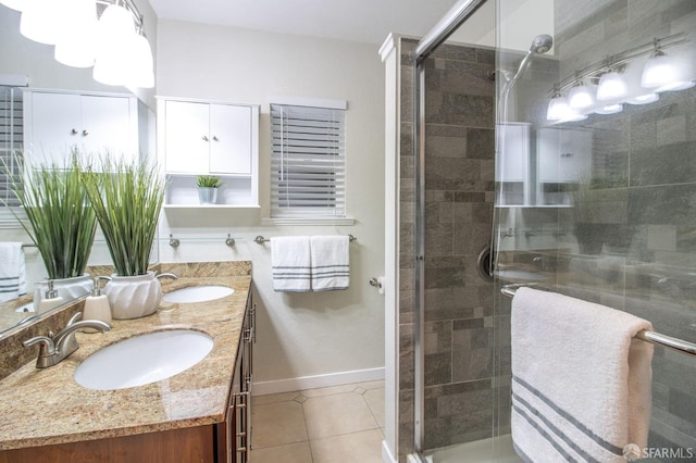 bathroom featuring tile patterned floors, a shower stall, and a sink