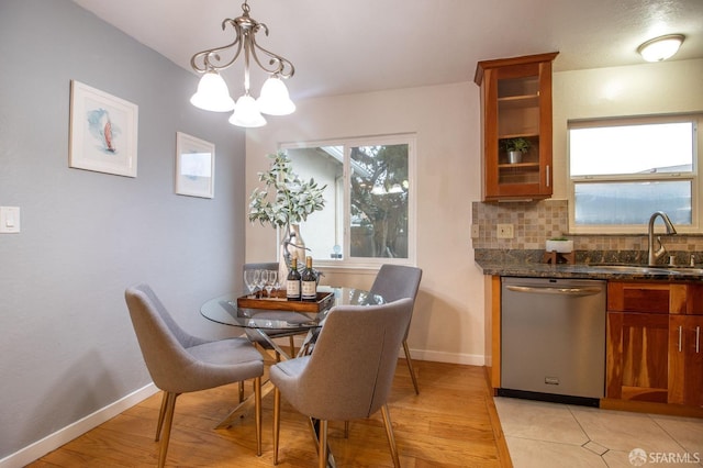 dining room featuring baseboards, light wood finished floors, and a chandelier