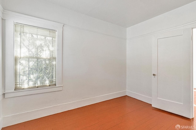 spare room featuring wood finished floors and baseboards