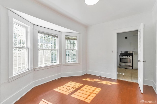 empty room featuring wood-type flooring and baseboards