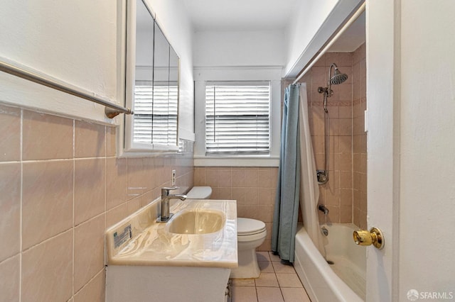 bathroom with shower / bath combination with curtain, vanity, toilet, tile walls, and tile patterned floors