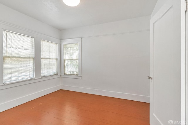empty room with baseboards and light wood-type flooring