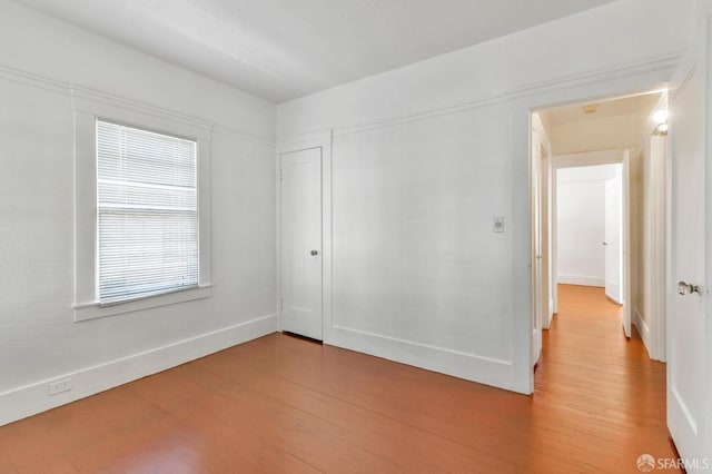 spare room with light wood-type flooring and baseboards