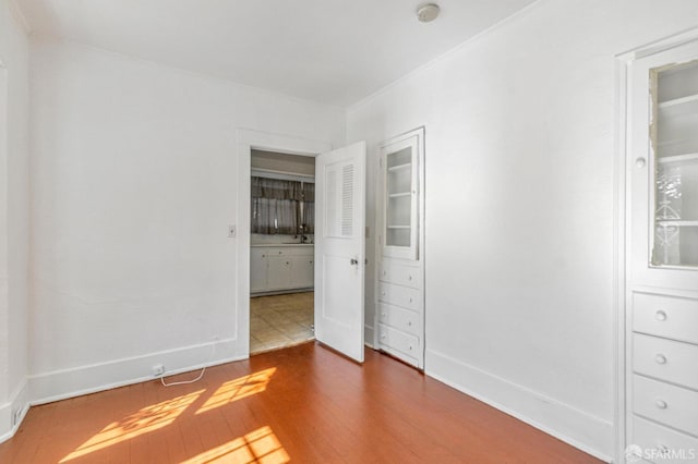 unfurnished bedroom with wood finished floors and baseboards