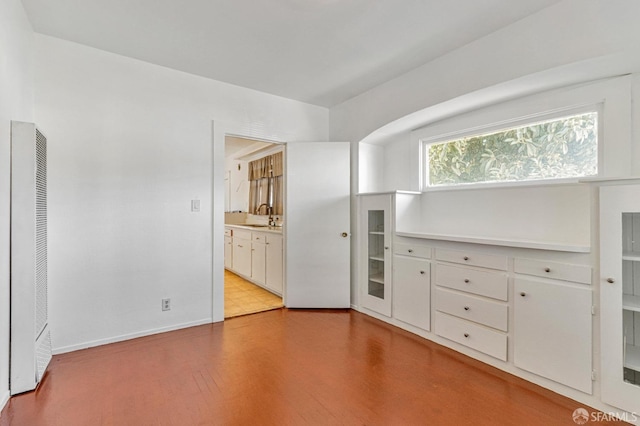 interior space with baseboards, a heating unit, and a sink