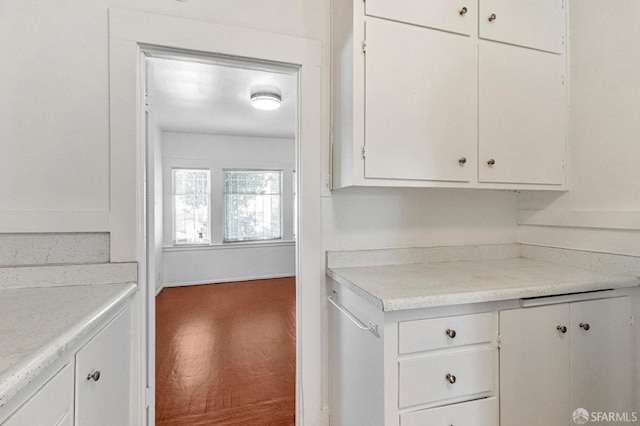 kitchen featuring carpet flooring, light countertops, and white cabinets