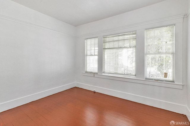 empty room with hardwood / wood-style flooring and baseboards