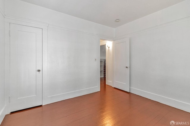 empty room featuring wood finished floors and baseboards