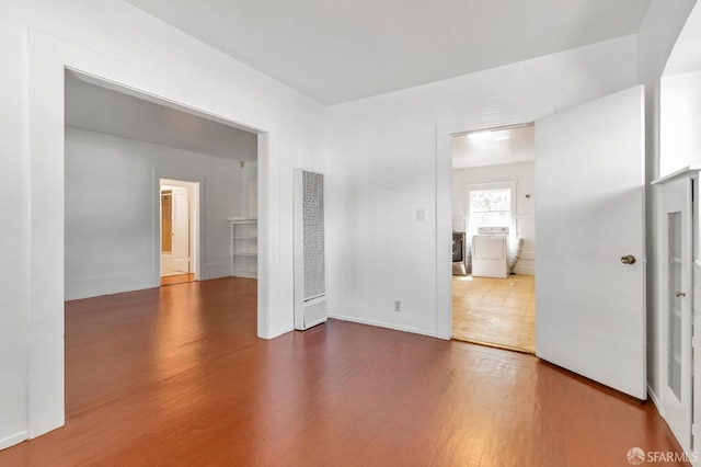 spare room with washer / dryer and wood-type flooring