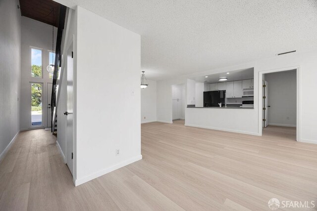 521 Ridgeview Ct, Pleasant Hill, CA 94523 - unfurnished living room featuring light wood-style flooring, a textured ceiling, and baseboards