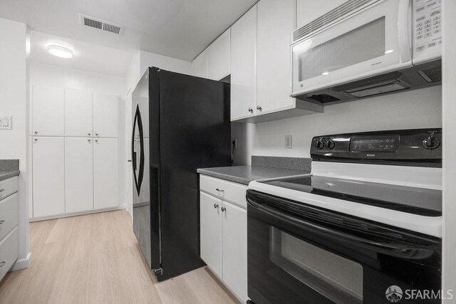 521 Ridgeview Ct, Pleasant Hill, CA 94523 - kitchen with range with electric cooktop, white microwave, freestanding refrigerator, light wood-style floors, and white cabinets