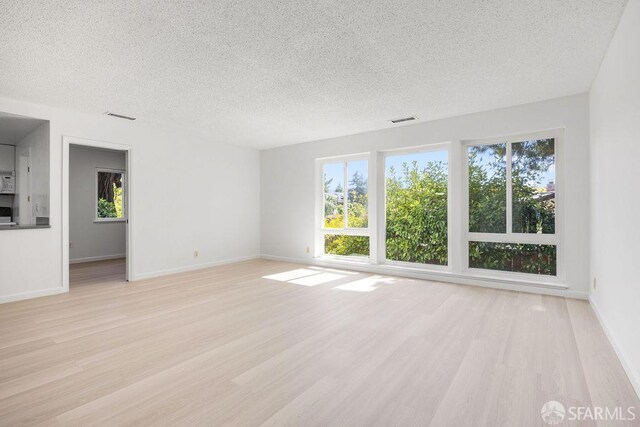 521 Ridgeview Ct, Pleasant Hill, CA 94523 - unfurnished living room featuring a textured ceiling, light wood-style floors, and baseboards