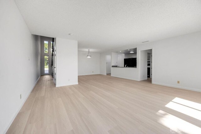 521 Ridgeview Ct, Pleasant Hill, CA 94523 - unfurnished living room featuring a textured ceiling, light wood-style flooring, and baseboards