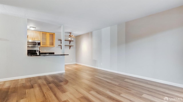 unfurnished living room with ceiling fan and light hardwood / wood-style flooring